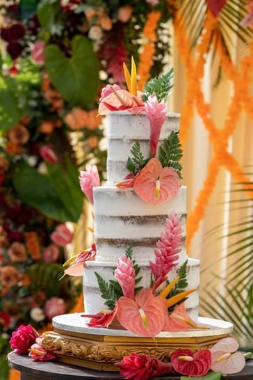 Fresh orchids, monstera leaves, and roses will add a tropical vibe to the cake.