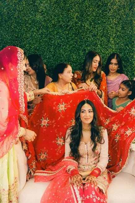 The groom’s family places a veil on the bride’s head to symbolize her acceptance as the bride-to-be for their family.